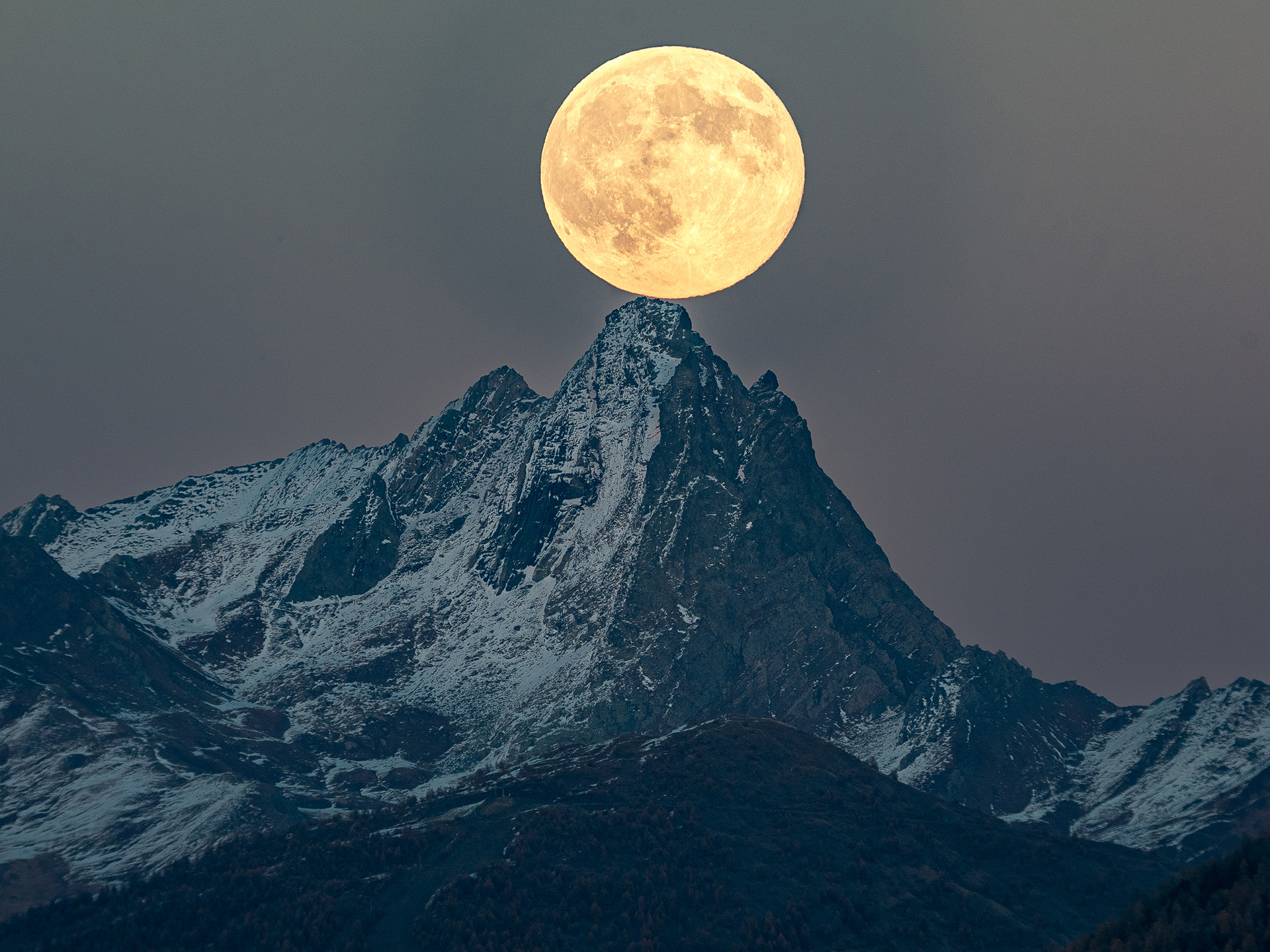 The Full Moon appears to touch the iconic peak of Bric Bouchet